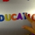 Hand Writes Education with Fridge Magnets Close-Up