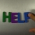 Hand Writes Help with Fridge Magnets Close-Up