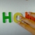 Hand Writes How with Fridge Magnets Close-Up