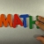 Hand Writes Math with Fridge Magnets Close-Up