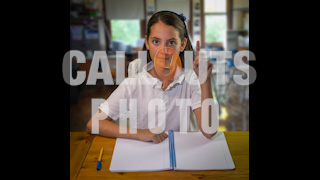 Student in Classroom With Hand Up