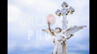 Angel Statue in Front of Cross Blue Cloudy Sky